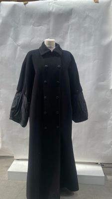 an image of a woman ' s black coat on display in front of a white backdrop