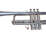 a silver trumpet that is sitting on a white surface