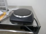 a stove top with a hot plate on it next to a toaster