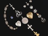 une collection de bijoux en argent et en or comprenant notamment un cœur, une croix et d'autres objets