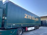 un semi-remorque vert garé sur un parking