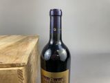 a bottle of wine sitting on a table next to a wooden box