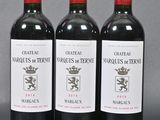 three bottles of red wine sitting next to each other on a table