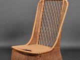 une image représentant une chaise en osier sur fond gris