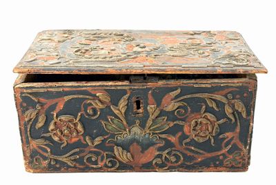 une vieille boîte en bois ornée d'un motif floral