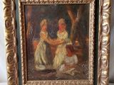 un vieux tableau représentant deux femmes, dans un cadre doré posé sur une surface blanche