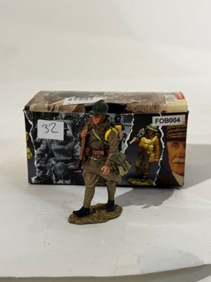 La figurine se tient à côté d'une boîte sur laquelle figure l'image d'un soldat.