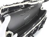 someone is holding a black and white purse with a black and white pattern