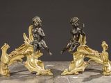 pair of antique bronze figurines of cherensils on a marble table