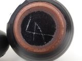 a close up of a black and brown vase and a black ball