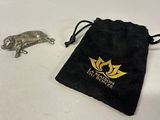 a small black bag with a gold logo next to a silver animal