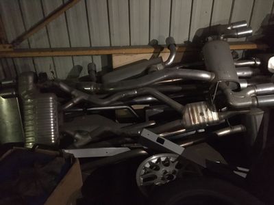 a pile of exhaust pipes and exhaust pipes in a garage