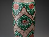 an image of a green and red vase sitting on top of a table