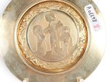 a gold plate with a picture of a woman and two children on it