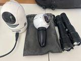 a camera, flashlight, and other items on a table
