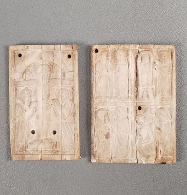 deux morceaux de bois percés de trous, posés sur une surface grise