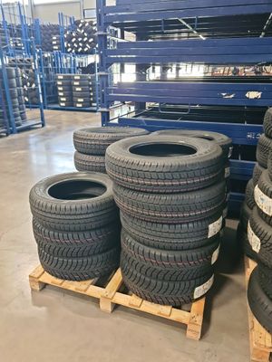 several tires stacked on pallets in a warehouse with pallets in the background