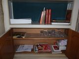 a small cabinet with a lot of books on top of it