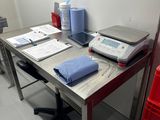 un bureau sur lequel se trouvent un ordinateur portable, une imprimante et d'autres objets
