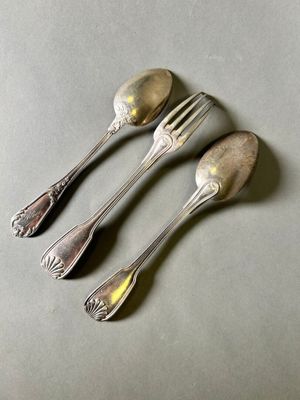 three silver spoons and a fork on a gray surface