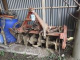 un tracteur équipé d'une charrue devant un bâtiment