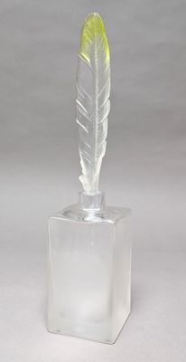 clear acrylic sculpture of a feather with a yellow feather tip
