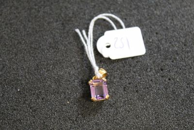 un pendentif en pierre améthore avec une étiquette sur un fond noir