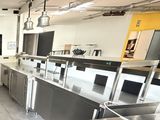 une grande cuisine équipée d'appareils électroménagers en inox et de plans de travail