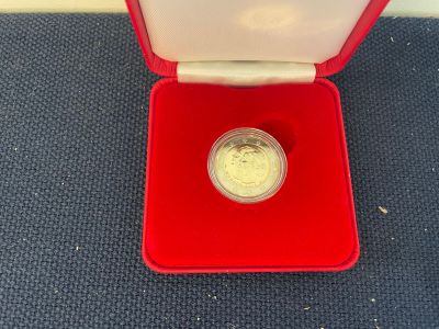 a gold coin in a red box on a blue carpet