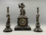 trois statues représentant un homme et une femme avec une horloge