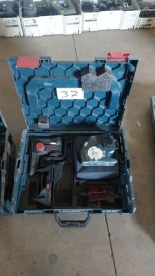 une caisse à outils bleue avec des outils sur le sol