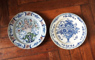 deux assiettes ornées de motifs bleus et blancs, posées sur un plancher en bois