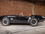 a black sports car parked in front of a brick wall