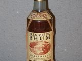 une bouteille de rhum posée sur une table devant un mur