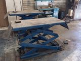 a close up of two scissor tables in a garage