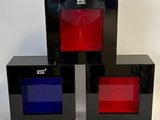 three black boxes with red, blue, and red glass in them