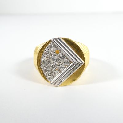 gros plan d'une bague en or et diamants sur une surface blanche