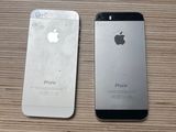 two iphones sitting side by side next to each other on a wooden table