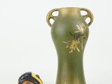 a green vase with a measuring tape next to it