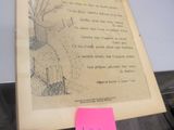 un vieux livre posé sur une table, avec un post-it rose dessus