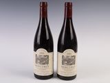 two bottles of red wine sitting next to each other on a table