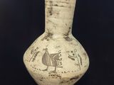 un vase avec un oiseau posé sur une table