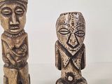 two wooden statues sitting next to each other on a table