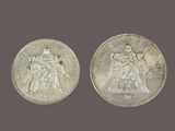 a close up of two silver coins on a gray background