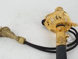 a gold colored handle with a black handle on a white surface