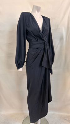 La robe est noire et a des manches longues.
