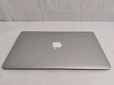 a silver apple laptop sitting on a white surface