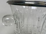 a clear glass vase with a silver lid on a table