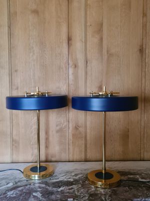 une paire de lampes de table en laiton et bleu posées sur un plateau en marbre