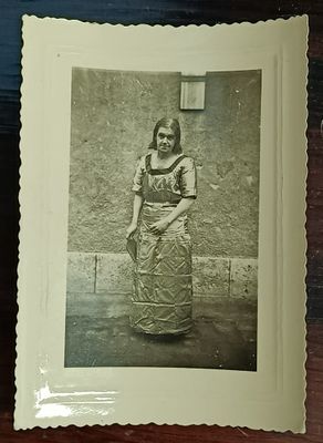 une photo d'une femme en robe, debout devant un mur